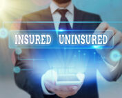Man pointing at phone with text sign showing “insured” and “uninsured.”